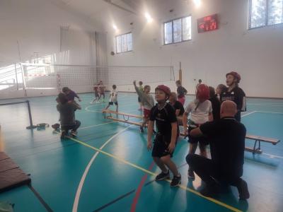 Dzieci biorą udział w zajęciach sportowych w hali sportowej na ściance wspinaczkowej.