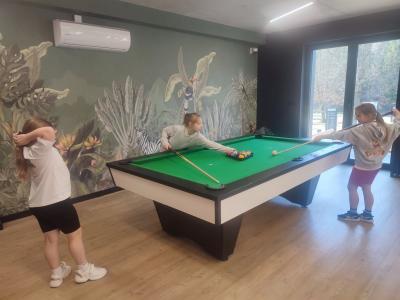 Dzieci grają w bilard, ping ponga w salce sportowej