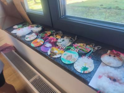 Kolorowe bombki z drewna ułożone na parapecie