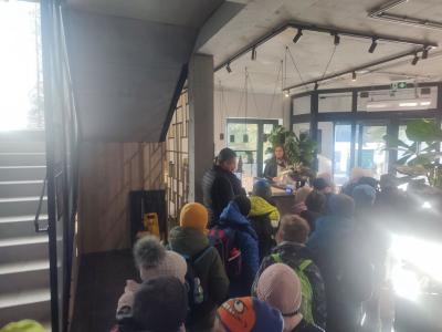 Uczniowie ustawieni parami wychodzą z budynku za nauczycielem