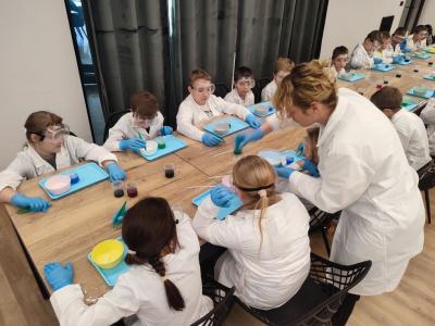 Uczniowie w czasie warsztatów chemicznych - eksperymenty z suchym lodem i zjawisko sublimacji