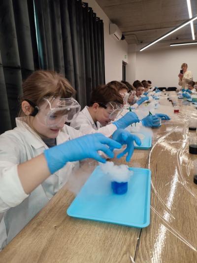 Uczniowie w czasie warsztatów chemicznych - eksperymenty z suchym lodem i zjawisko sublimacji
