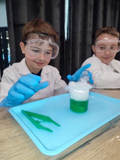 Uczniowie w czasie warsztatów chemicznych - eksperymenty z suchym lodem i zjawisko sublimacji