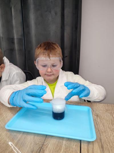 Uczniowie w czasie warsztatów chemicznych - eksperymenty z suchym lodem i zjawisko sublimacji