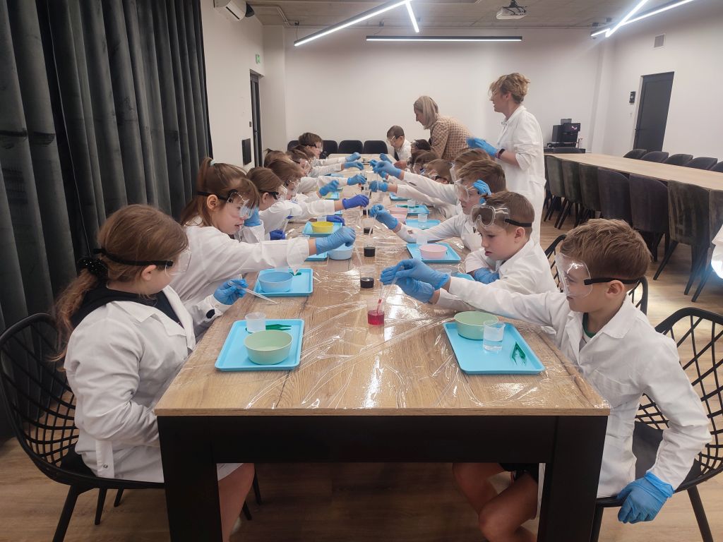 Dzieci biorą udział w warsztatach chemicznych
