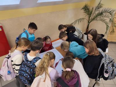 Uczniowie zbierający wpisy na plakat co można robić bez telefonu