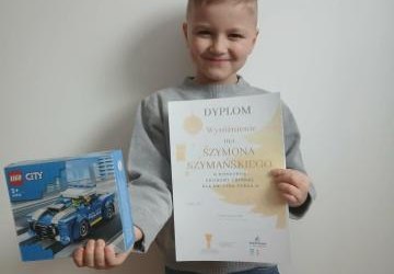 Szymon z dyplomem i nagrodą