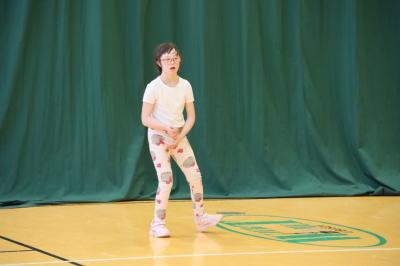 Uczennica tańczy na scenie.