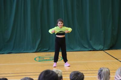 Uczennica tańczy na scenie.