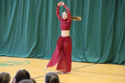 Uczennica tańczy na scenie.