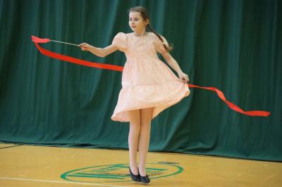 Uczennica tańczy na scenie.