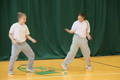 Uczennice tańczą na scenie.