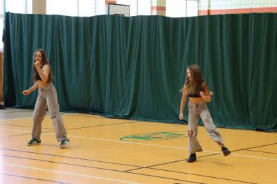 Uczennice tańczą na scenie.