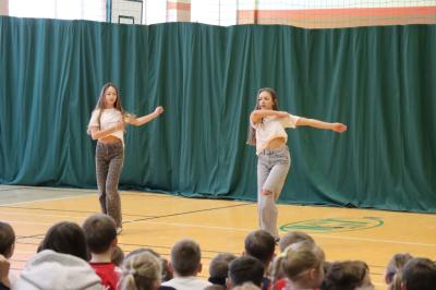 Uczennice tańczą na scenie.