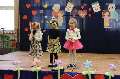 Przedszkolaki stoją na scenie, witają gości.