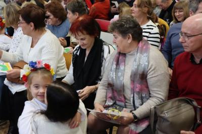 Wnuki wręczają upominki swoim dziadkom