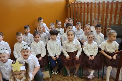 Przedszkolaki z grupy Leśne Duszki pozują do zdjęcia, siedzą obok sceny