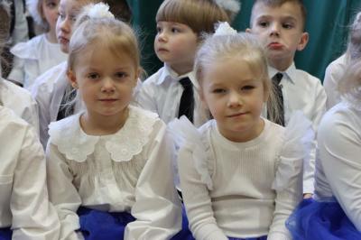 Przedszkolaki z grupy Biedronki pozują do zdjęcia siedząc obok sceny.