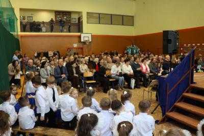 Zdjęcie zebranych gości  w hali sportowej.