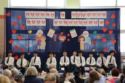 Przedszkolaki z grupy Biedronki występują na scenie w biało-niebieskich strojach