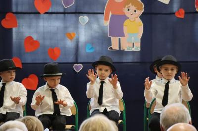 Przedszkolaki z grupy Biedronki występują na scenie w biało-niebieskich strojach