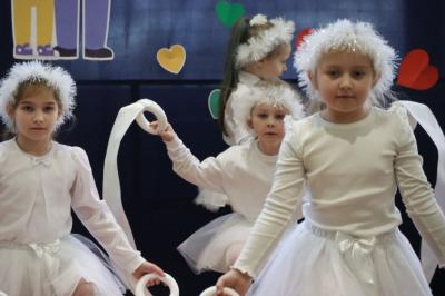 Przedszkolaki z grupy Skrzaty występują na scenie w białych strojach