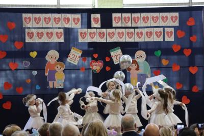 Przedszkolaki z grupy Skrzaty występują na scenie w białych strojach