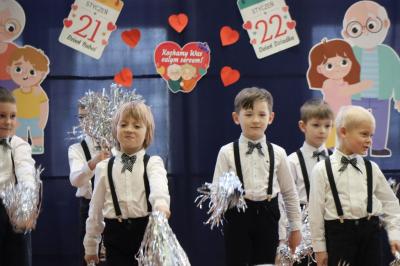 Przedszkolaki z grupy Skrzaty występują na scenie w białych strojach