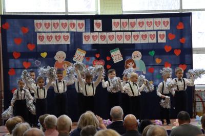 Przedszkolaki z grupy Skrzaty występują na scenie w białych strojach