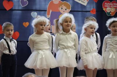 Przedszkolaki z grupy Skrzaty występują na scenie w białych strojach