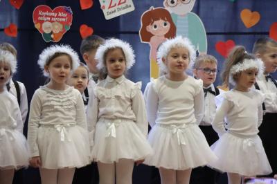 Przedszkolaki z grupy Skrzaty występują na scenie w białych strojach