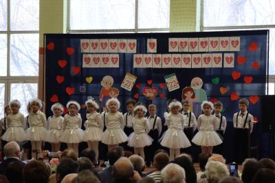 Przedszkolaki z grupy Skrzaty występują na scenie w białych strojach