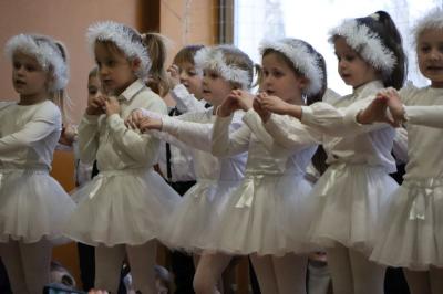 Przedszkolaki z grupy Skrzaty występują na scenie w białych strojach