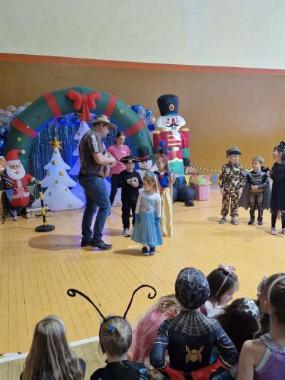 Konkurs podczas zabawy karnawałowej - kilka dzieci stoi na środku, pozostałe siedzą na parkiecie