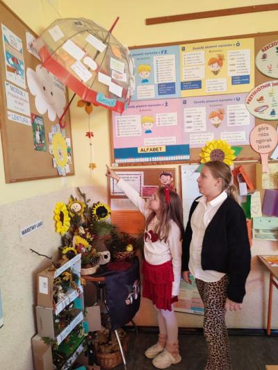 Dwie dziewczynki stoją przy gazetce ściennej.