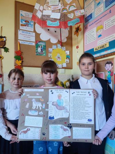 Uczniowie pozują do zdjecia, trzymają plakat.