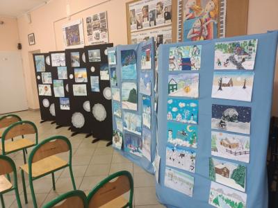 prace uczestników wiszące na niebieskim i czarnym tle