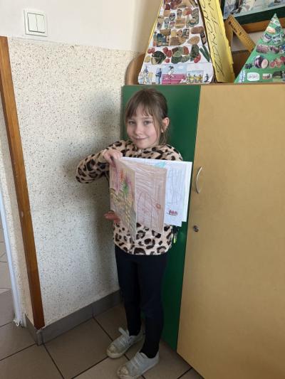 uczennica klasy 1a trzyma książeczkę z ilustarcjami do książeczki 