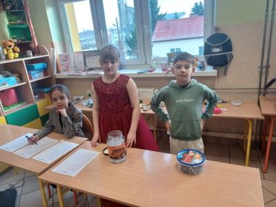 Troje dzieci na stanowisku loterii fantowej.