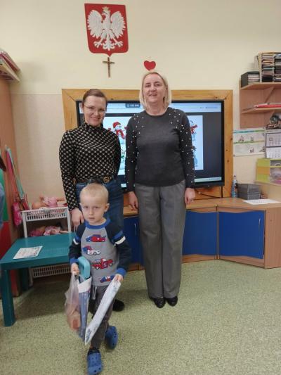 Chłopczyk wraz z nauczycielkami pozuje do wspólnego zdjęcia