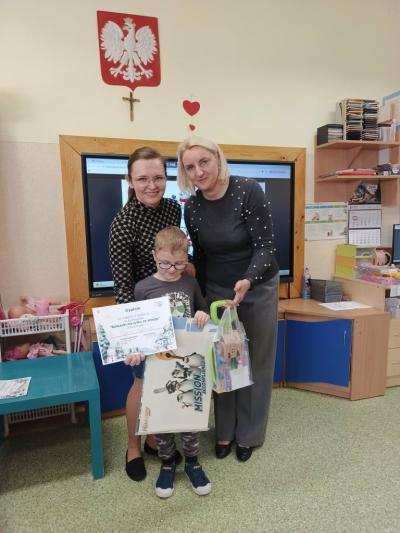 Chłopczyk wraz z nauczycielkami pozuje do wspólnego zdjęcia