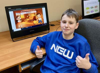 Uczeń pozuje do zdjęcia na tle zbobytego certyfikatu