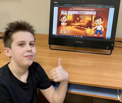 Uczeń pozuje do zdjęcia na tle zbobytego certyfikatu