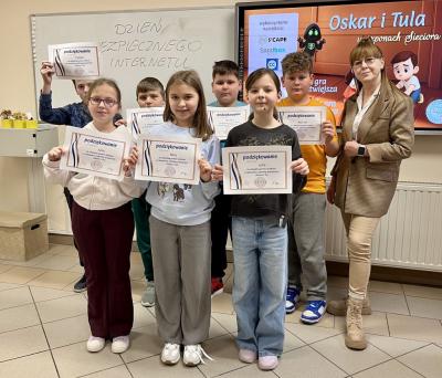 Uczniowie pozują do zdjęcia z certyfikatami