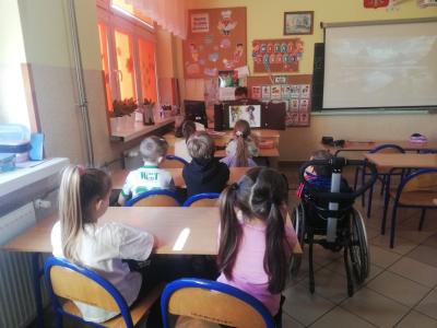 Nauczyciel czyta uczniom opowiadanie w formie teatrzyku kamishibai