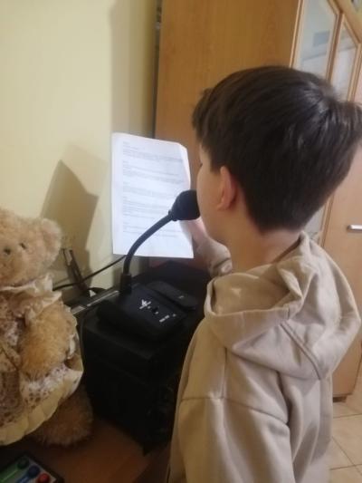 uczeń czyta tekst przez szkolny radiowęzeł
