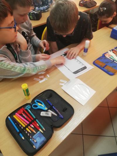 Uczniowie naklejają wyciete wyrazy