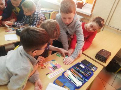 Uczniowie układają puzzle z rozciętego obrazka.