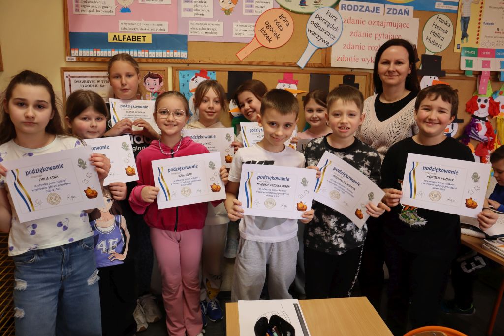 Uczniowie pozują do zdjęcia z certyfikatami