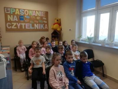 Pierwszoklasiści siedzą na krzesełkach